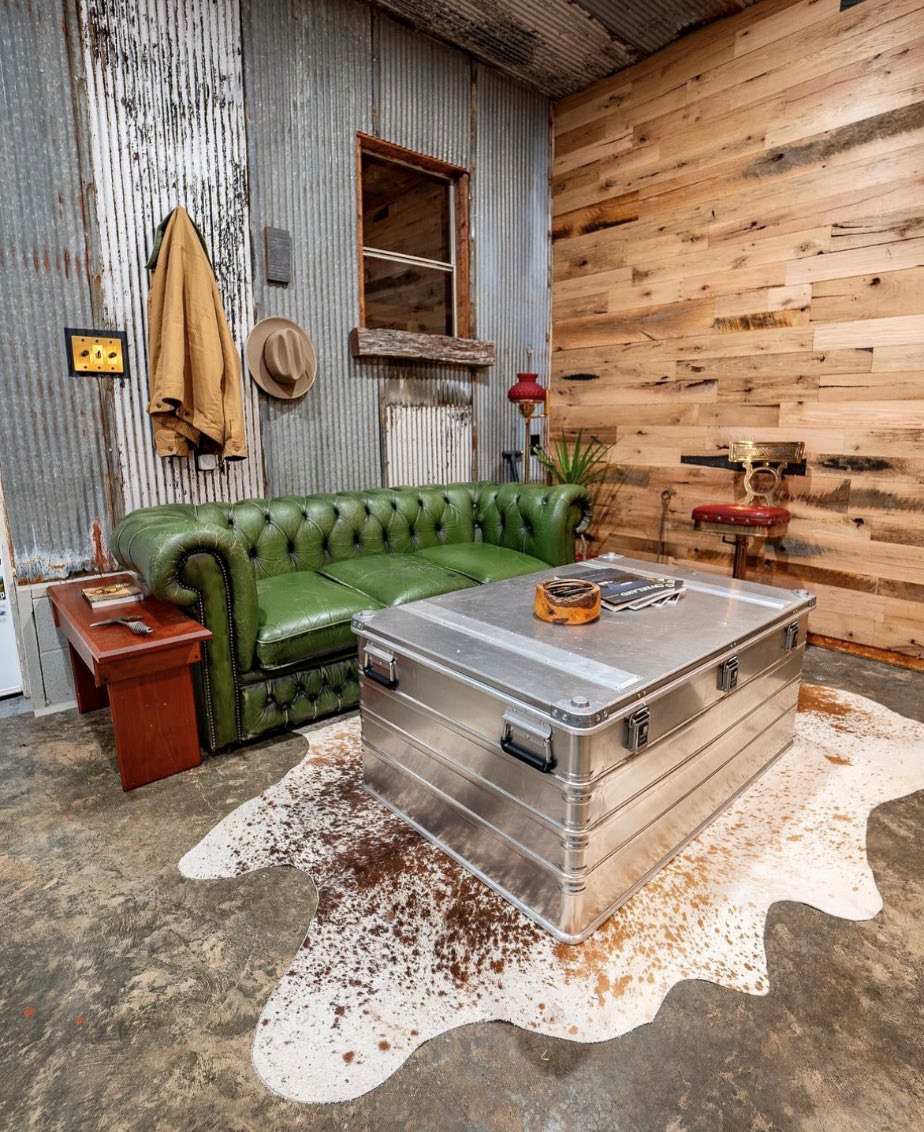 ZARGES K470-40580 case used as a coffee table on a cowhide rug beside a green leather sofa