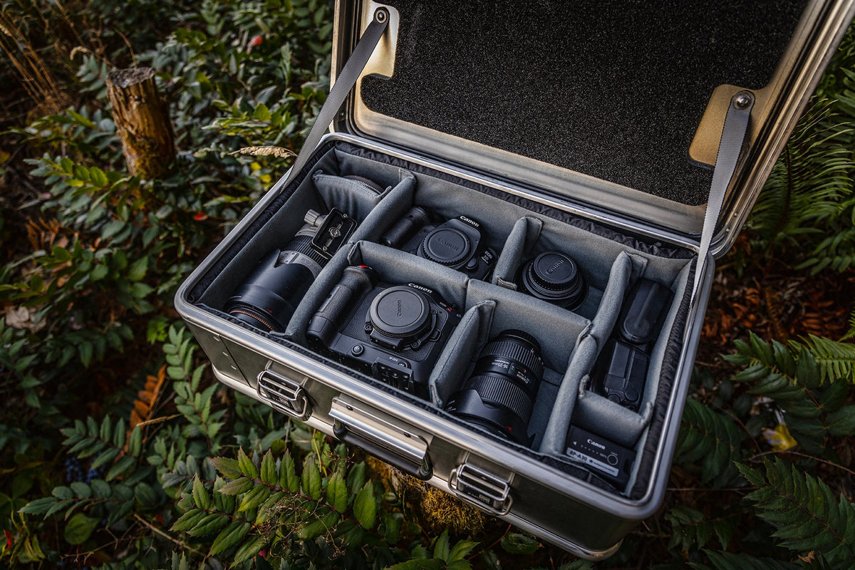 ZARGES case open on a forest floor, Interior Divider Set holding camera bodies and lenses