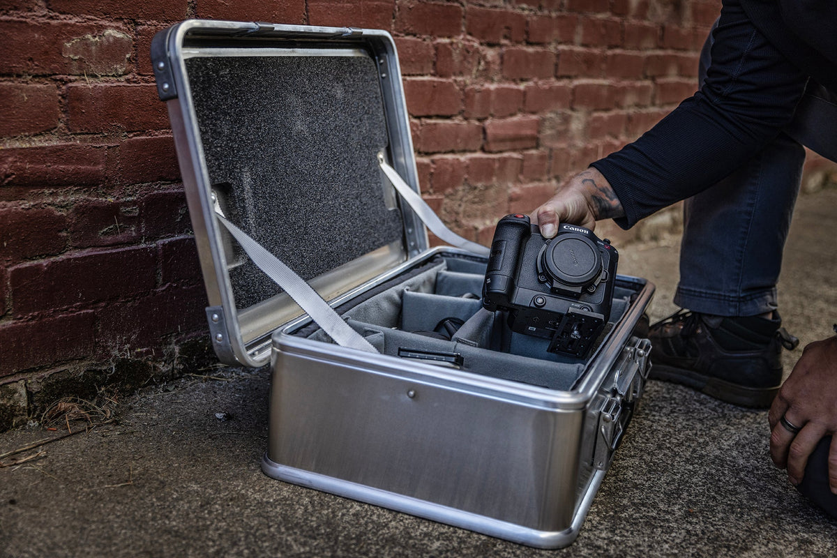 Camera set into the Interior Divider Set of an open ZARGES case against a red brick wall