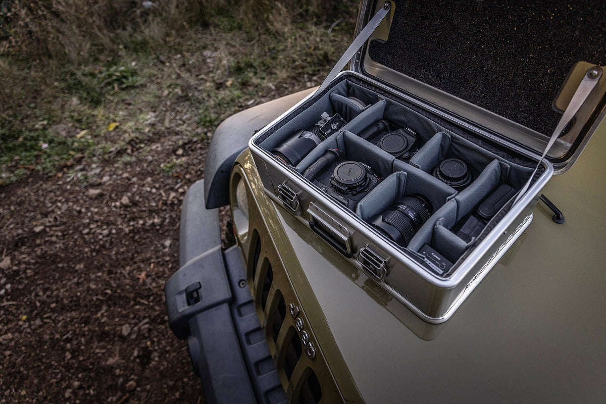 Open ZARGES case on a vehicle hood, Interior Divider Set organizing lenses and camera gear