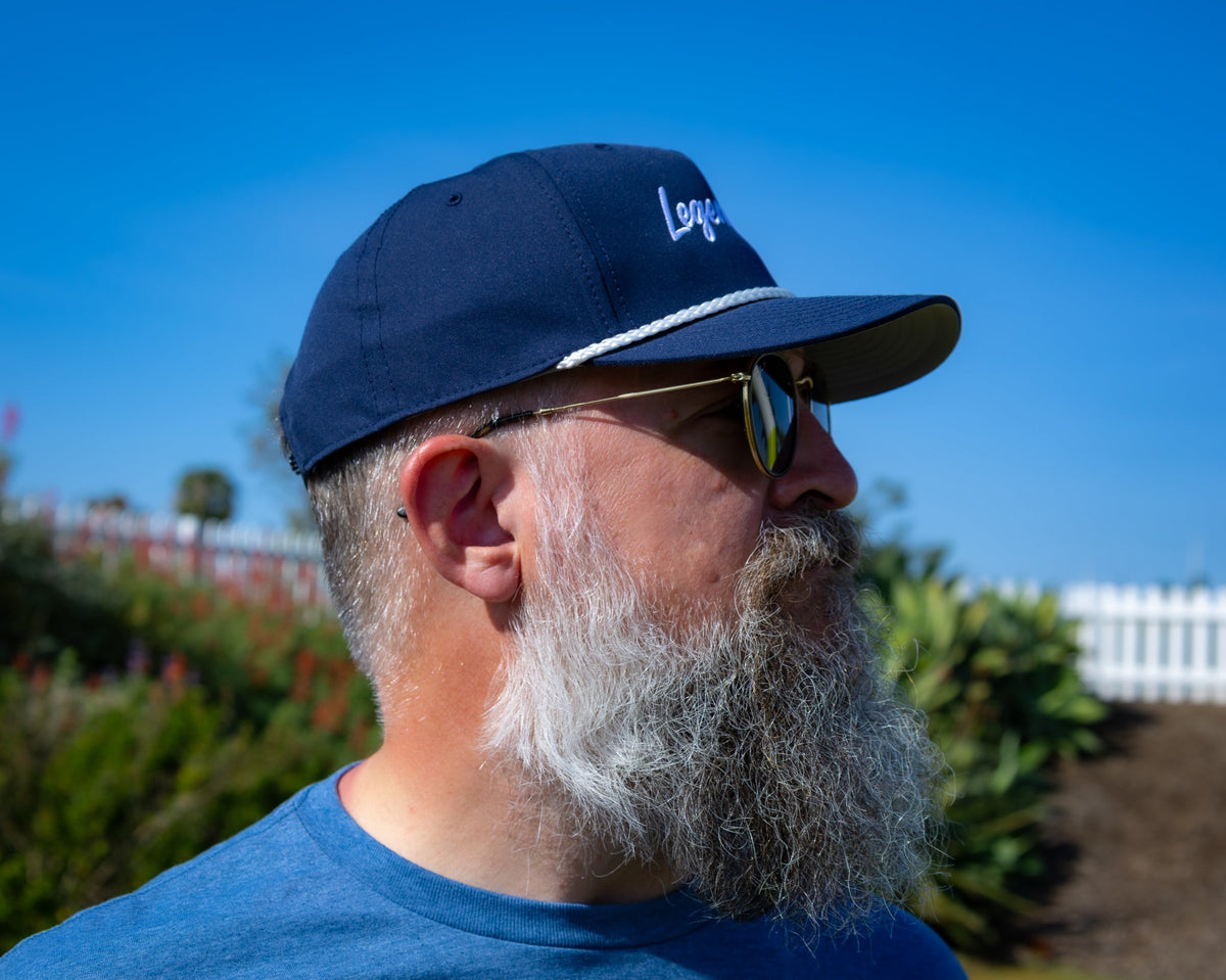 Right-side profile of a bearded man wearing the ZARGES Legendary Navy Blue Rope Hat under a blue sky