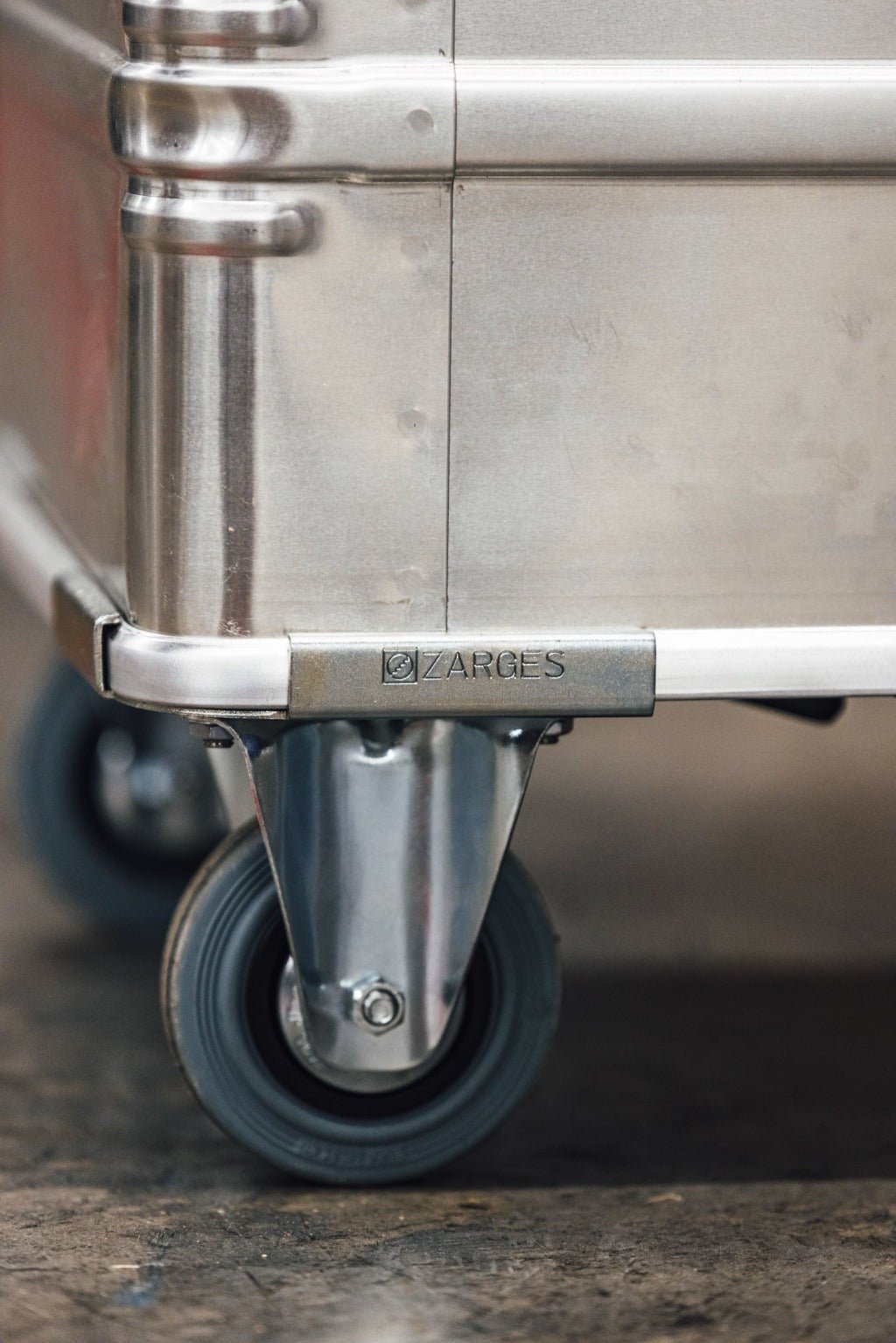 Close-up of a ZARGES caster wheel mounted under the corner of an aluminum case