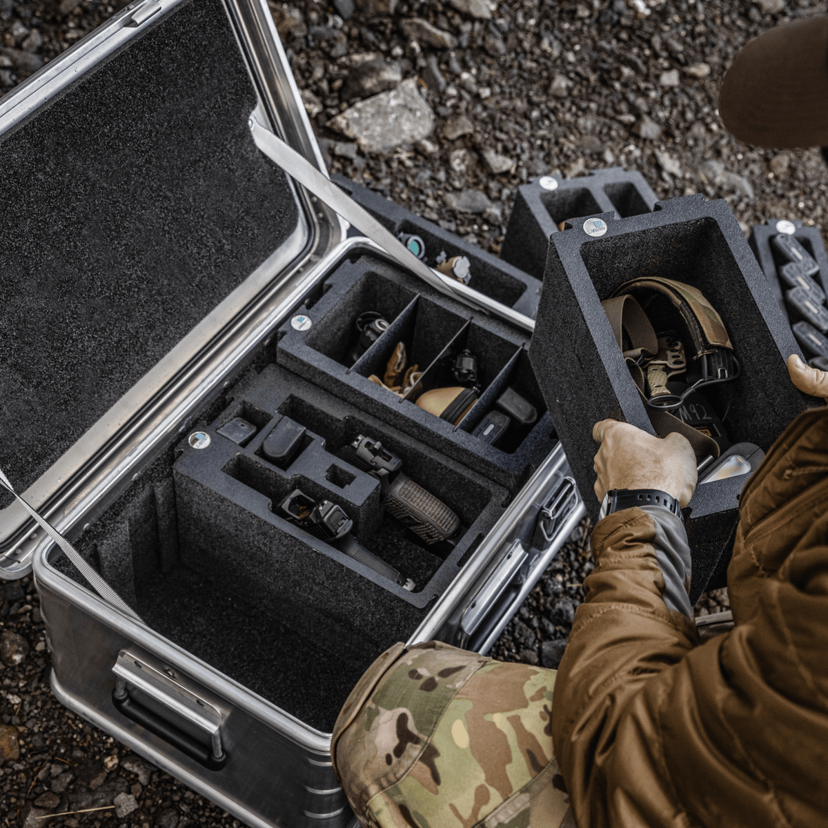 Person lifting a ZARGES Chameleon Double-Wide Open foam module of gear out of an open case outdoors
