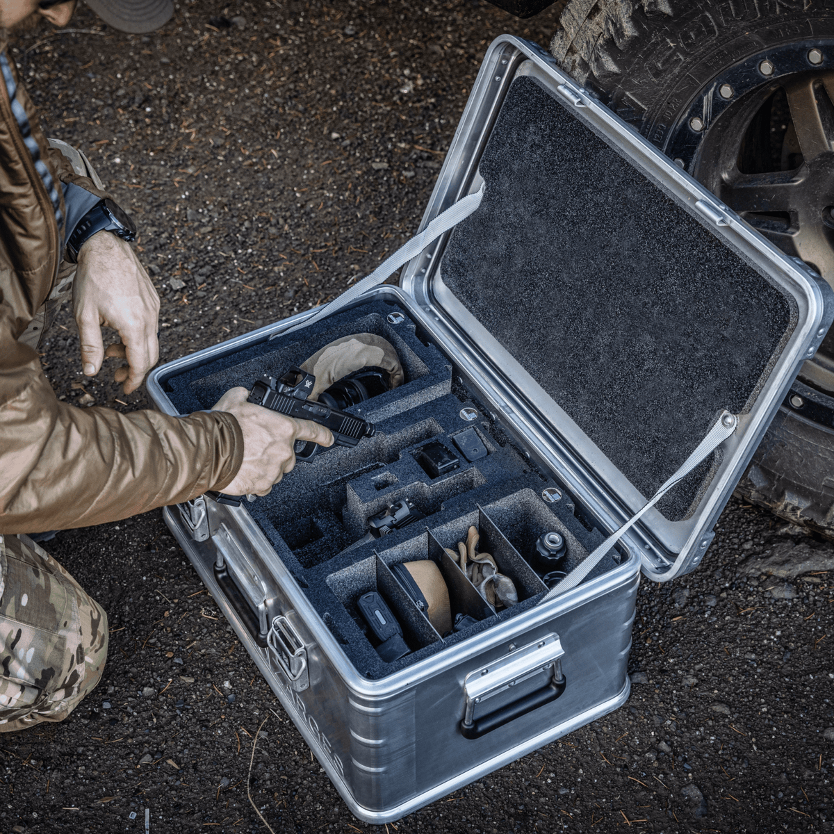 Kneeling man packs gear into ZARGES Chameleon Module - Double Wide with Dividers inside an open case