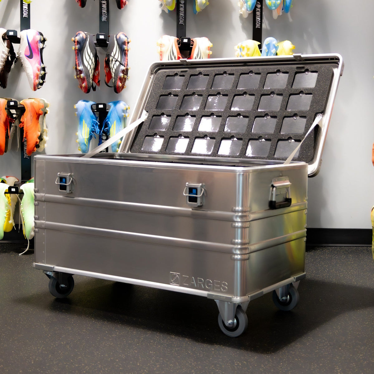 ZARGES Cleat Case on casters with lid open, grid of cleat compartments, in a cleat locker room