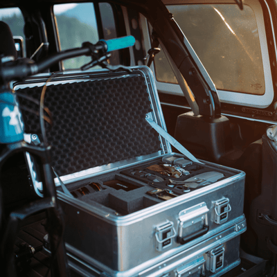 ZARGES K470-40810 case open in a vehicle cargo area, drone gear seated in black foam cutouts
