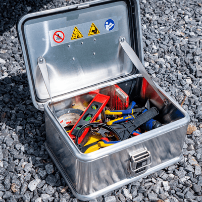 ZARGES K470-40835 open on gravel, filled with hand tools, a level, pliers and a tape measure