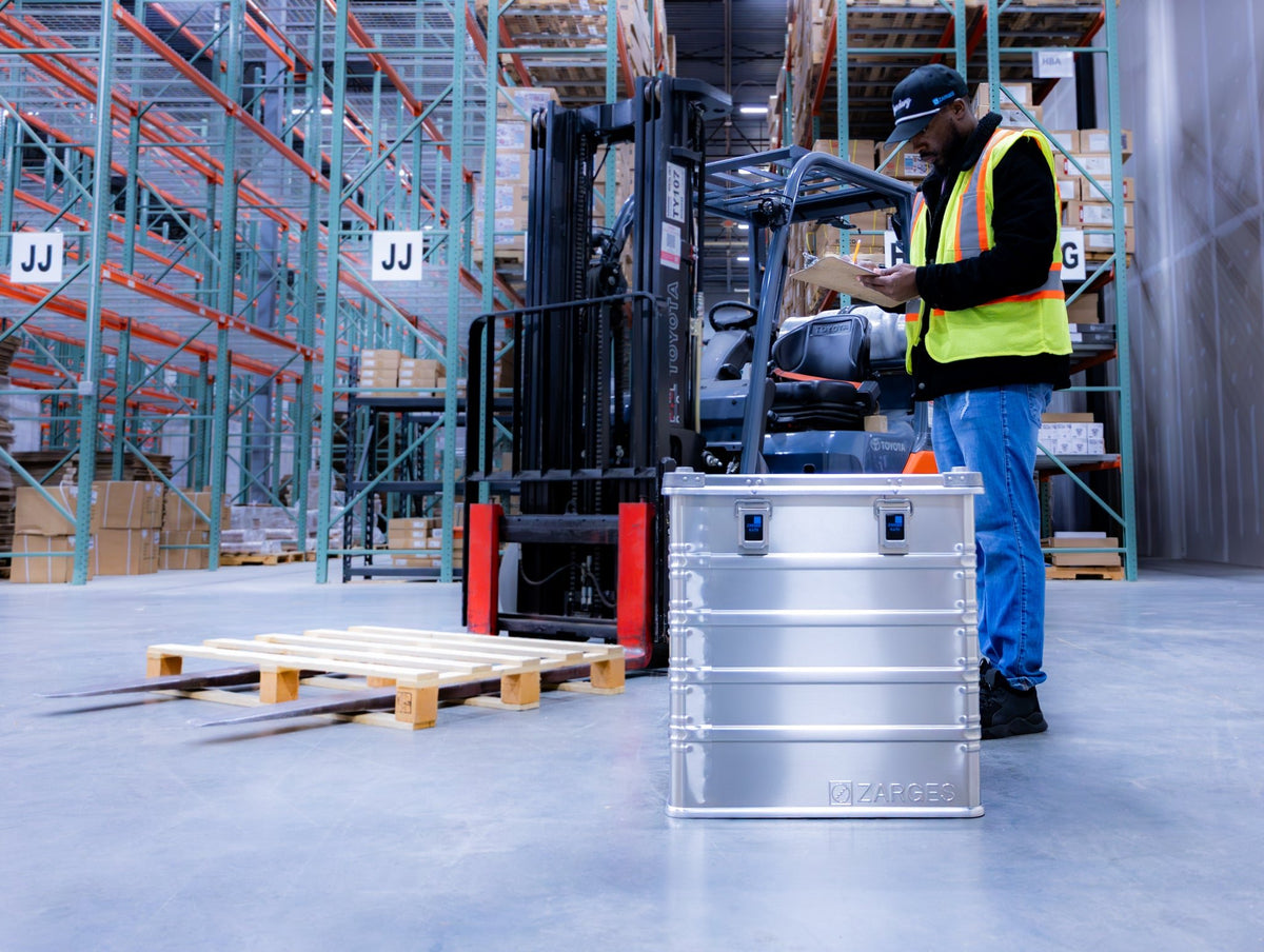 ZARGES K470-40836 aluminum case on a warehouse floor as a worker with a clipboard looks on
