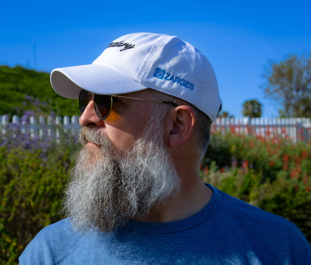 Side profile of a bearded man in the white ZARGES Legendary 47' Hat showing the side logo