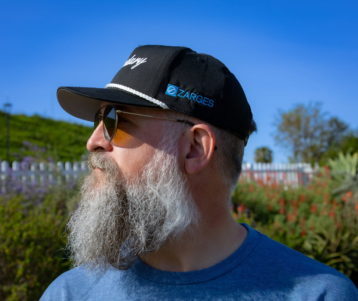 Bearded man wearing the ZARGES Legendary Black Rope Hat, side view showing the blue ZARGES logo