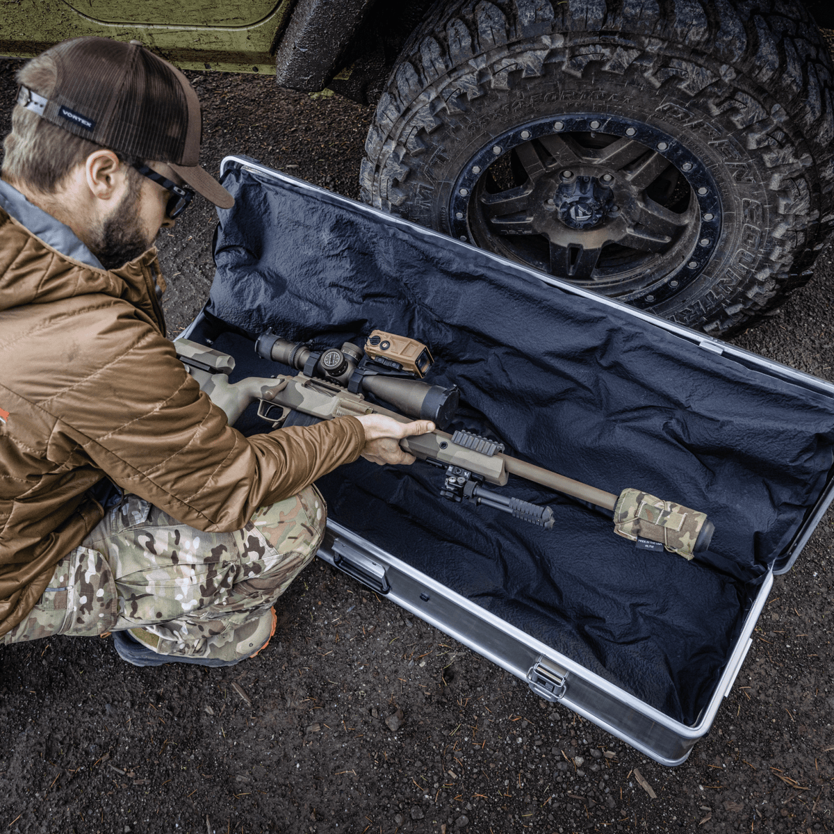 Man in camo lays a scoped rifle on the KOR cushions inside an open ZARGES Single Long Rifle KOR Kit case
